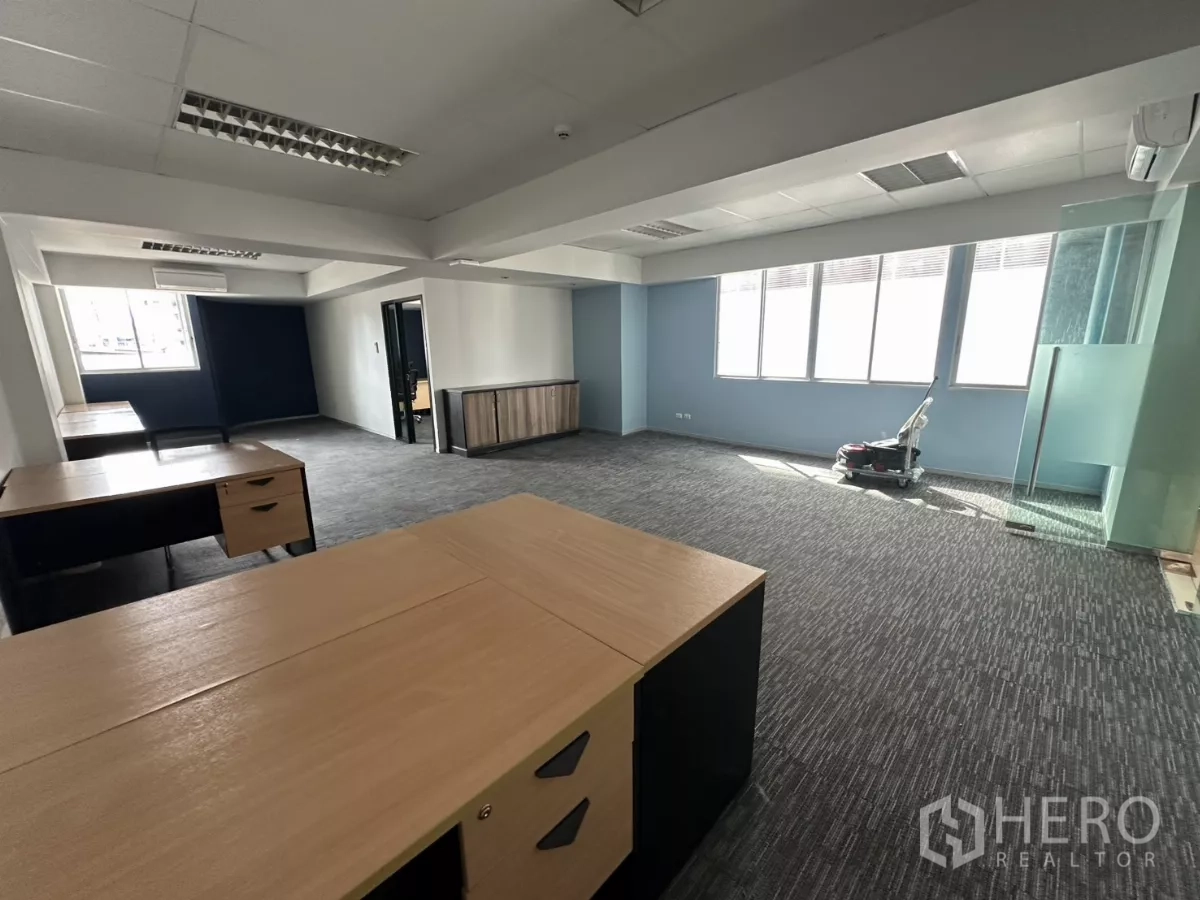 办公空间 出租在Watthana, Bangkok - 带家具的办公室角度视图，多张办公桌、玻璃入口与明亮窗户。