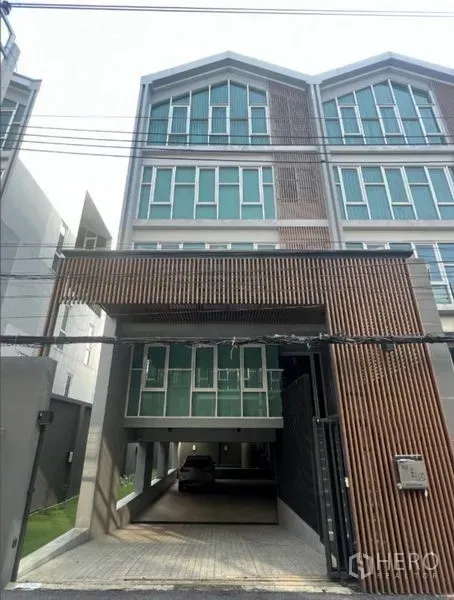 带办公室的家 出售在Phra Khanong, Bangkok - 当代多层家居办公外立面，大窗与有顶停车位。
