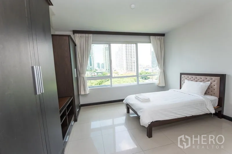 公寓 出租在Sathon, Bangkok - 采光充足的卧室，瓷砖地面与大幅景观窗。