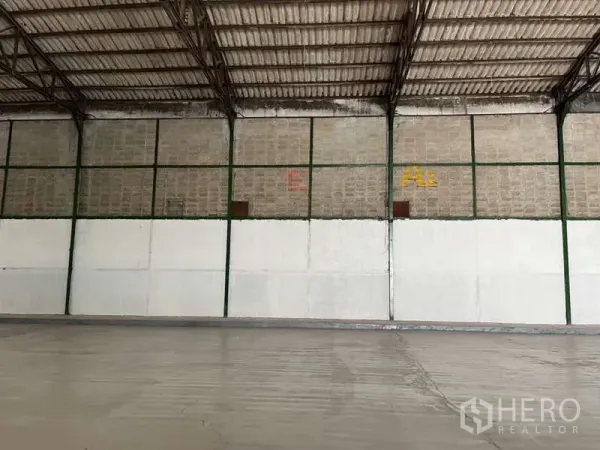 Factory for rent in Bang Pakong, Chachoengsao - Close-up of interior wall sections with steel framing and half-height white panels inside the factory.