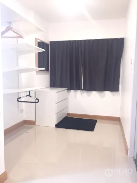 公寓 出租在Watthana, Bangkok - 白色步入式衣帽区，开放层板、挂衣杆、抽屉柜，窗户配深色窗帘。
