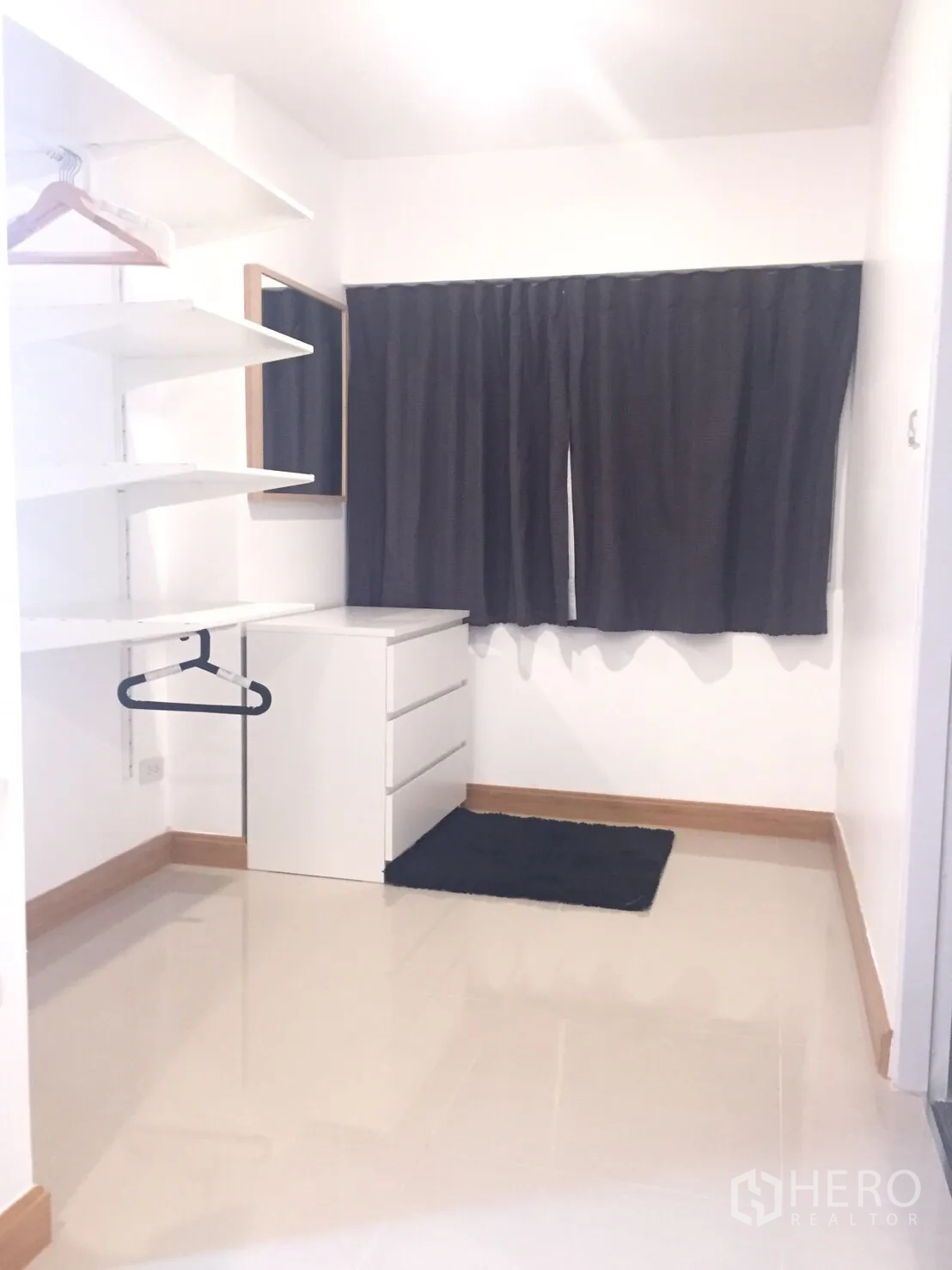 公寓 出租在Watthana, Bangkok - 白色步入式衣帽区，开放层板、挂衣杆、抽屉柜，窗户配深色窗帘。
