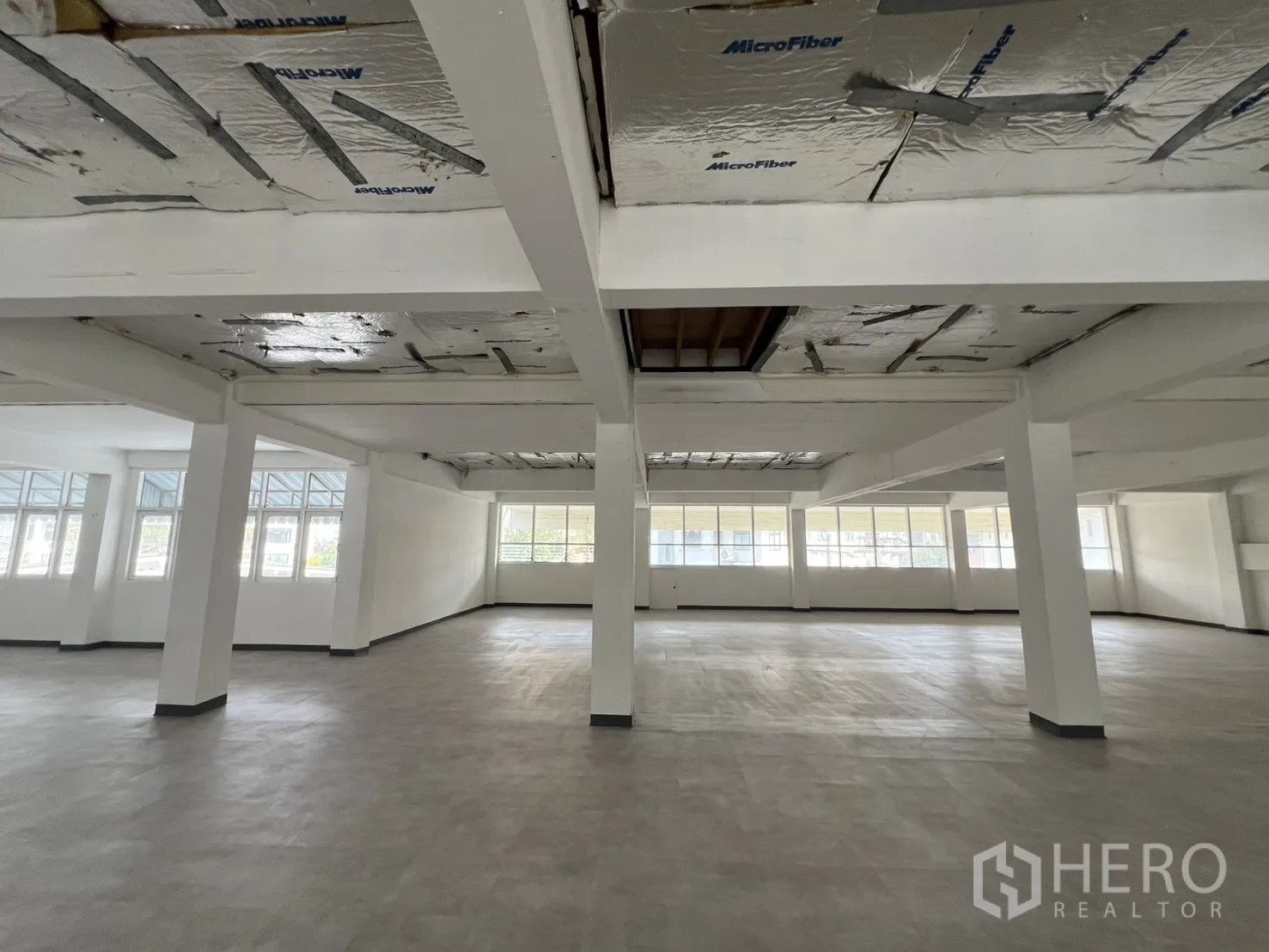 办公空间 出租在Watthana, Bangkok - 开放式办公楼层，结构梁柱与转角窗实现良好通风。