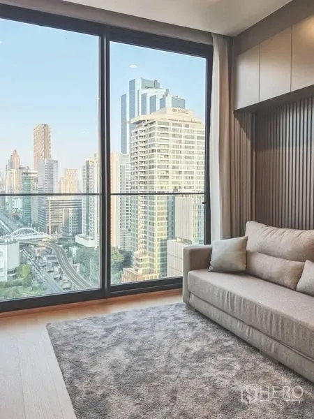 公寓 出租在Bang Rak, Bangkok - 沙发靠大型推拉落地窗，无遮挡高楼景观。