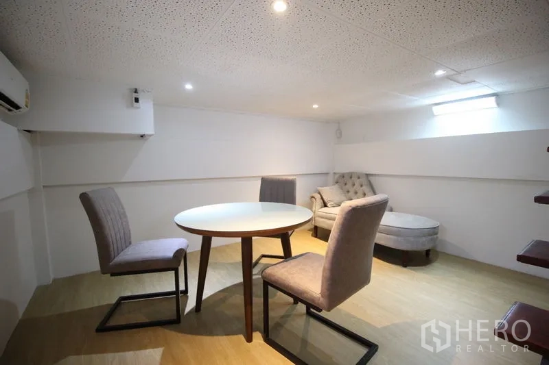 Detached House for rent in Chatuchak, Bangkok - Multipurpose room with round table and chairs, chaise lounge, wood flooring, low ceiling, and air conditioning.