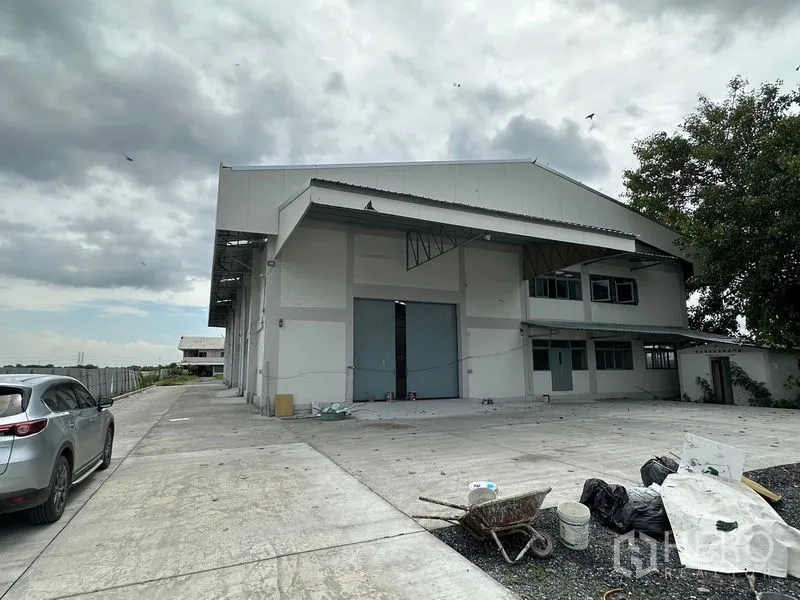 工厂 出租在Lam Luk Ka, Pathum Thani - 正面立面，覆盖式装卸区、停车位与车道。