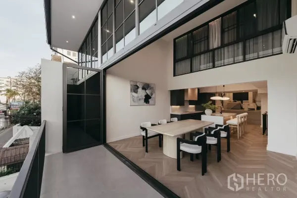 Townhouse for rent in Watthana, Bangkok - Open dining room folding to balcony with double-height glazing and indoor-outdoor flow.
