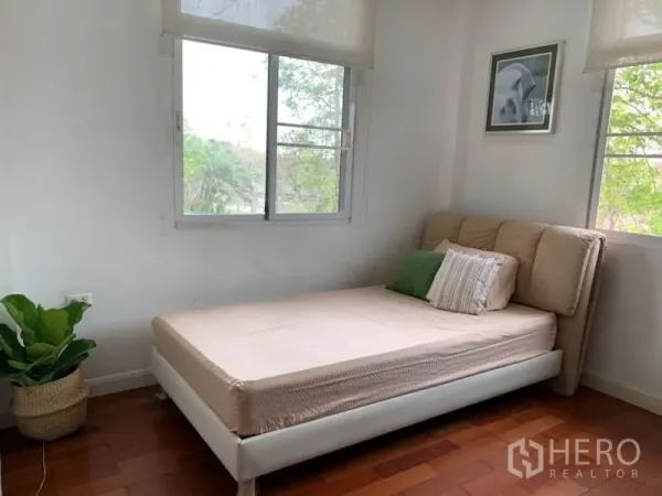 Detached House for rent in Lat Krabang, Bangkok - Bright bedroom with single bed, corner windows and a potted plant.