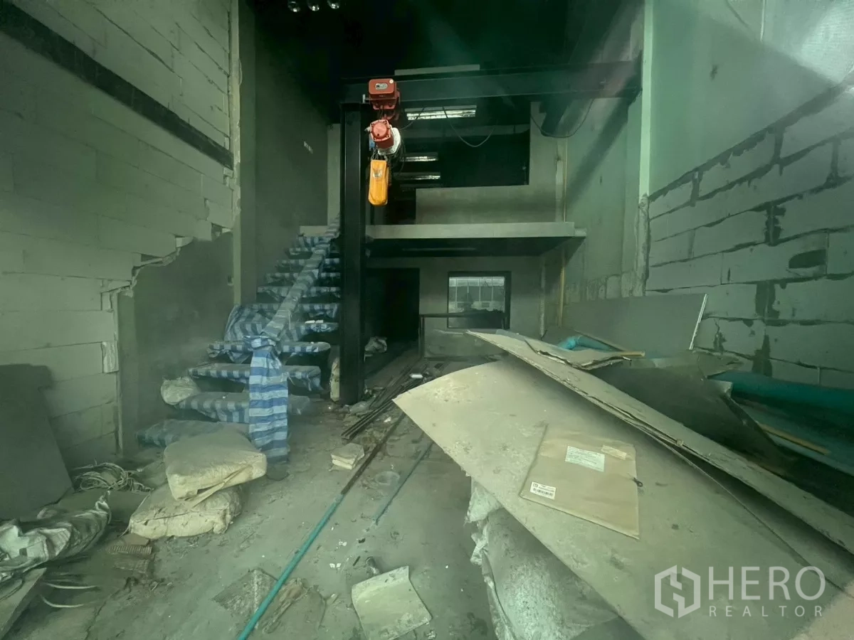 Shophouse for sale - Raw shophouse space featuring a stairway, steel beams, and a partially built mezzanine level.