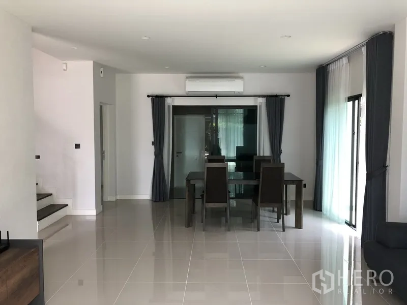 Detached House for rent in Bang Kapi, Bangkok - Bright dining area with air conditioning, dark curtains, and sliding glass doors in a modern home.
