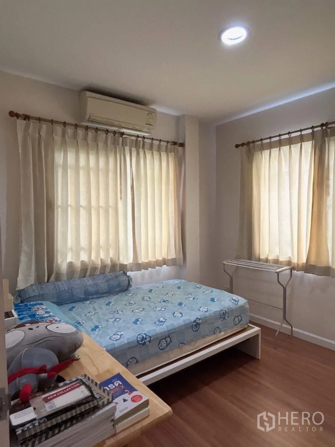 Detached House for sale in Bang Kapi, Bangkok - Cozy third bedroom with corner windows, bed, and wall-mounted air conditioner.