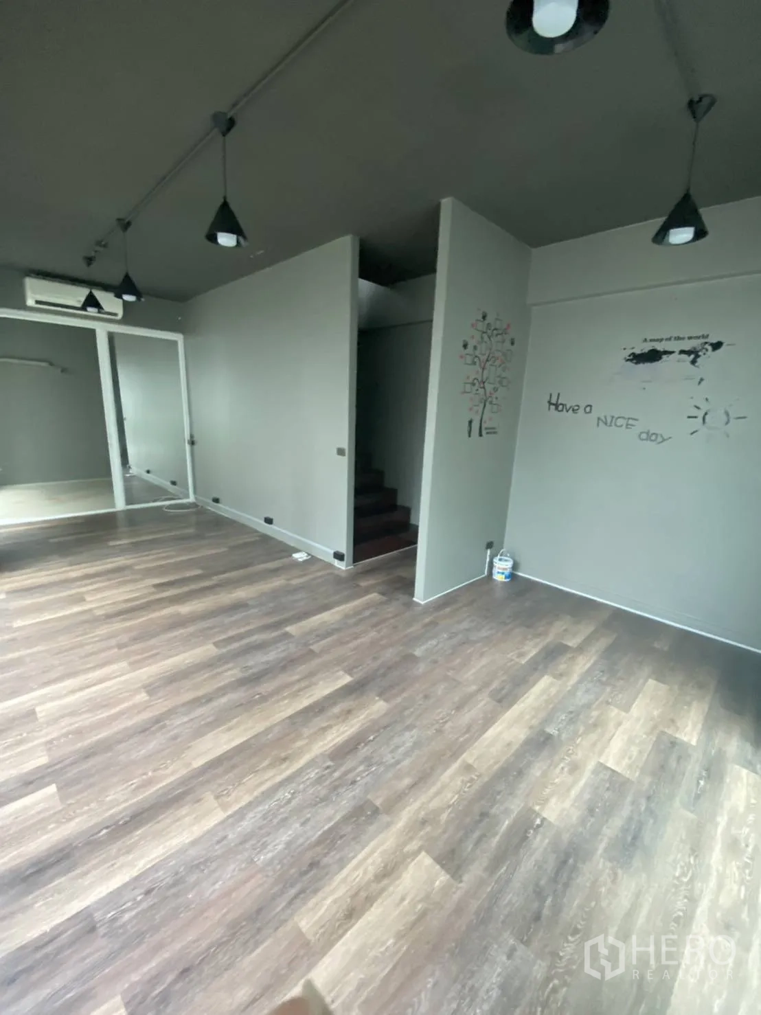 Retail Space for rent in Huai Khwang, Bangkok - Retail interior with pendant lights, grey walls, wood floors and a staircase.