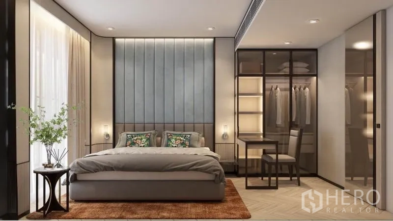 Condominium for rent in Watthana, Bangkok - Modern bedroom with padded headboard, floor‑to‑ceiling window, glass wardrobe with lighting, and a small work desk.