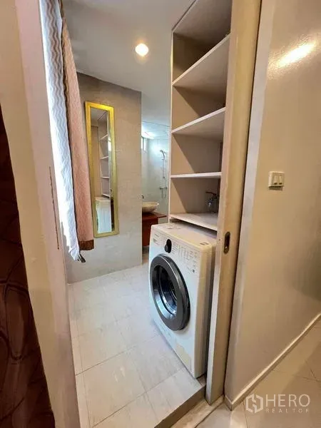 公寓 出租在Ratchathewi, Bangkok - 紧凑洗衣角，配前置洗衣机与开放式置物架，旁接浴室。