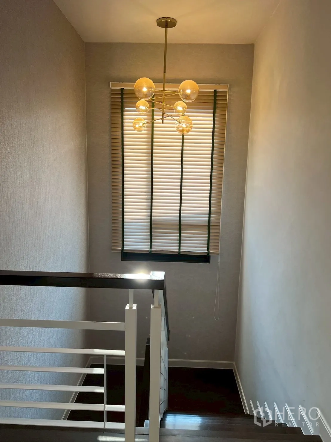 Detached House for rent in Bang Kapi, Bangkok - Stairwell with contemporary globe chandelier and tall window with blinds.