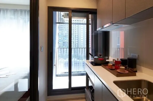 公寓 出售在Ratchathewi, Bangkok - 一字型厨房，柜体与水槽，连通可看城市景观的阳台。