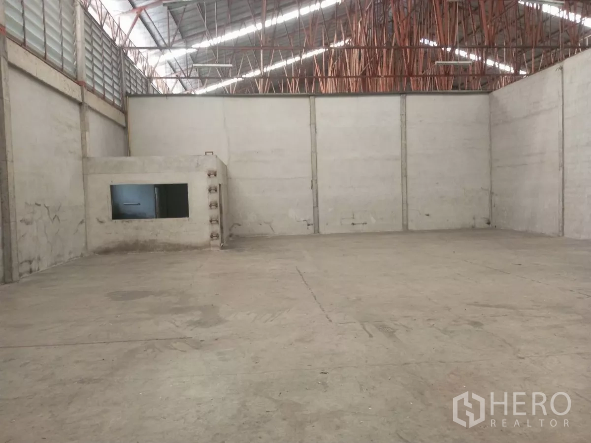 货栈 出租在Min Buri, Bangkok - 宽敞仓库地面与钢结构屋顶，角落设有内建办公室。