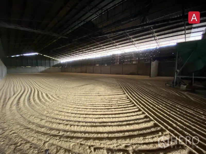 Factory for rent in Chachoengsao - Column‑free warehouse floor with skylight strip and neatly patterned bulk material.