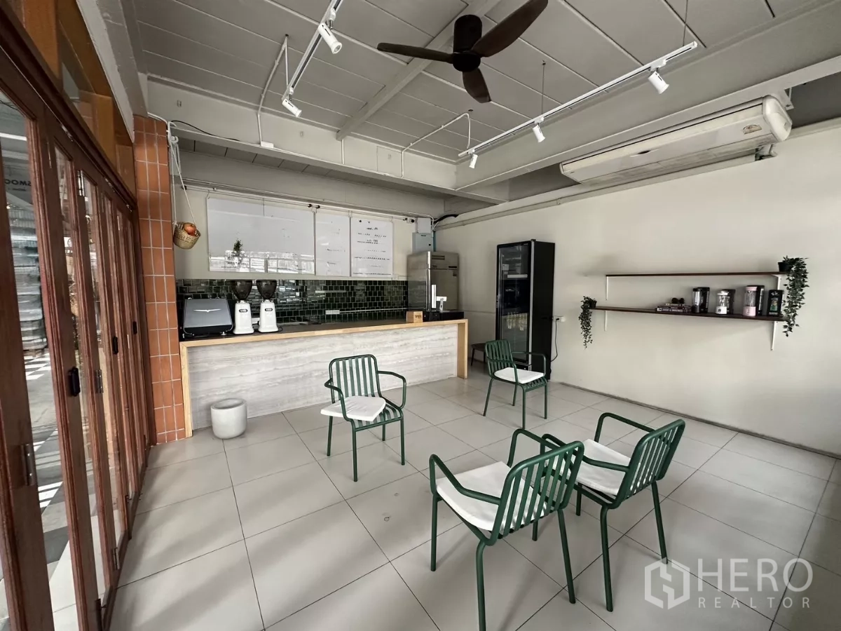 Retail Space for rent in Watthana, Bangkok - Front bar and cashier area with green tile backsplash, cafe equipment and sliding glass storefront doors.