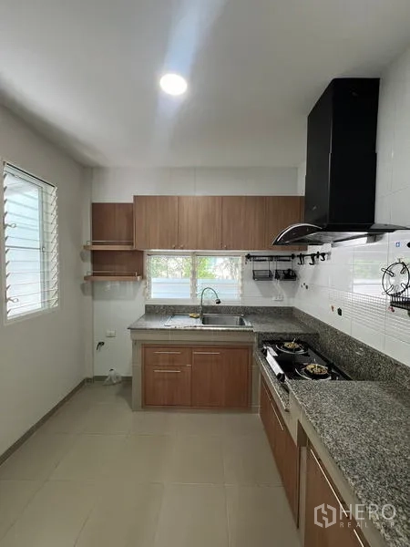 Detached House for rent in Bang Kapi, Bangkok - Thai kitchen alternate view with twin windows and ample cabinetry.