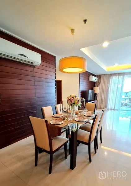Apartment for rent in Khlong Toei, Bangkok - Dining room with pendant lamp and doorway leading to the modern kitchen.