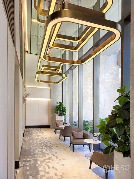 公寓 出租或出售在Pathum Wan, Bangkok - 挑高大堂，金色现代吊灯、休闲座椅与落地窗