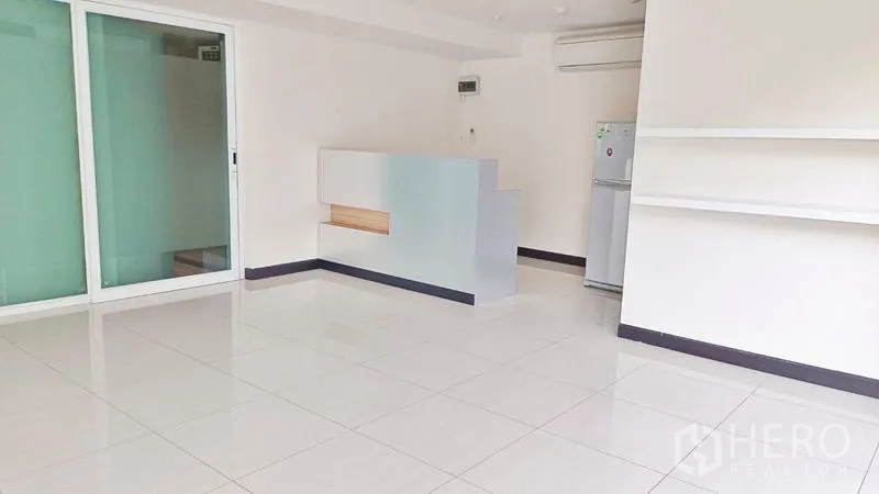 Retail Space for rent - Bright retail space with white tiles, sliding glass partition and reception counter.