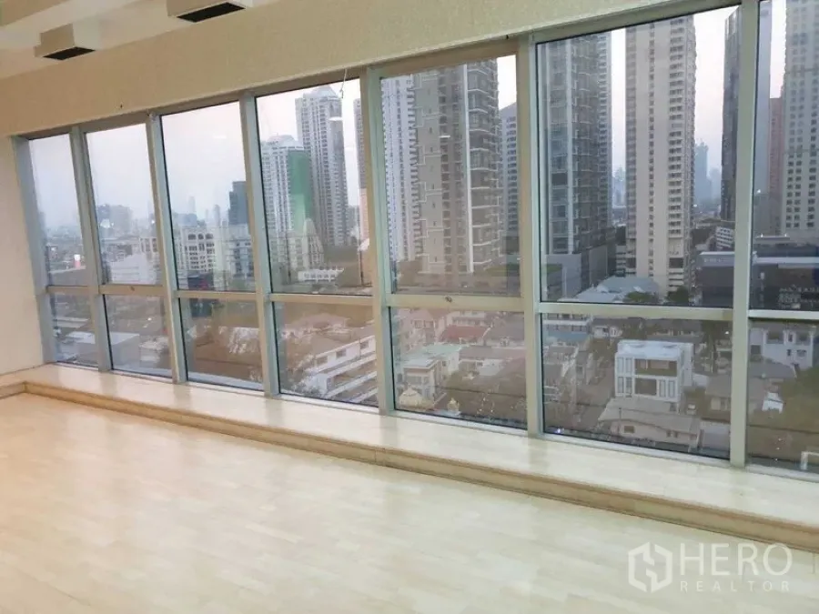 Office Space for rent - Panoramic windows with city skyline views and light wood flooring in the office.