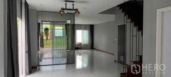 Townhouse for rent or sale in Saphan Sung, Bangkok - Spacious ground-floor living and dining zone with large windows and garden outlook.