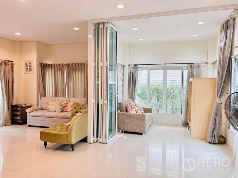 Detached House for rent - Another angle of the bright living area showing folding glass doors and wide windows.