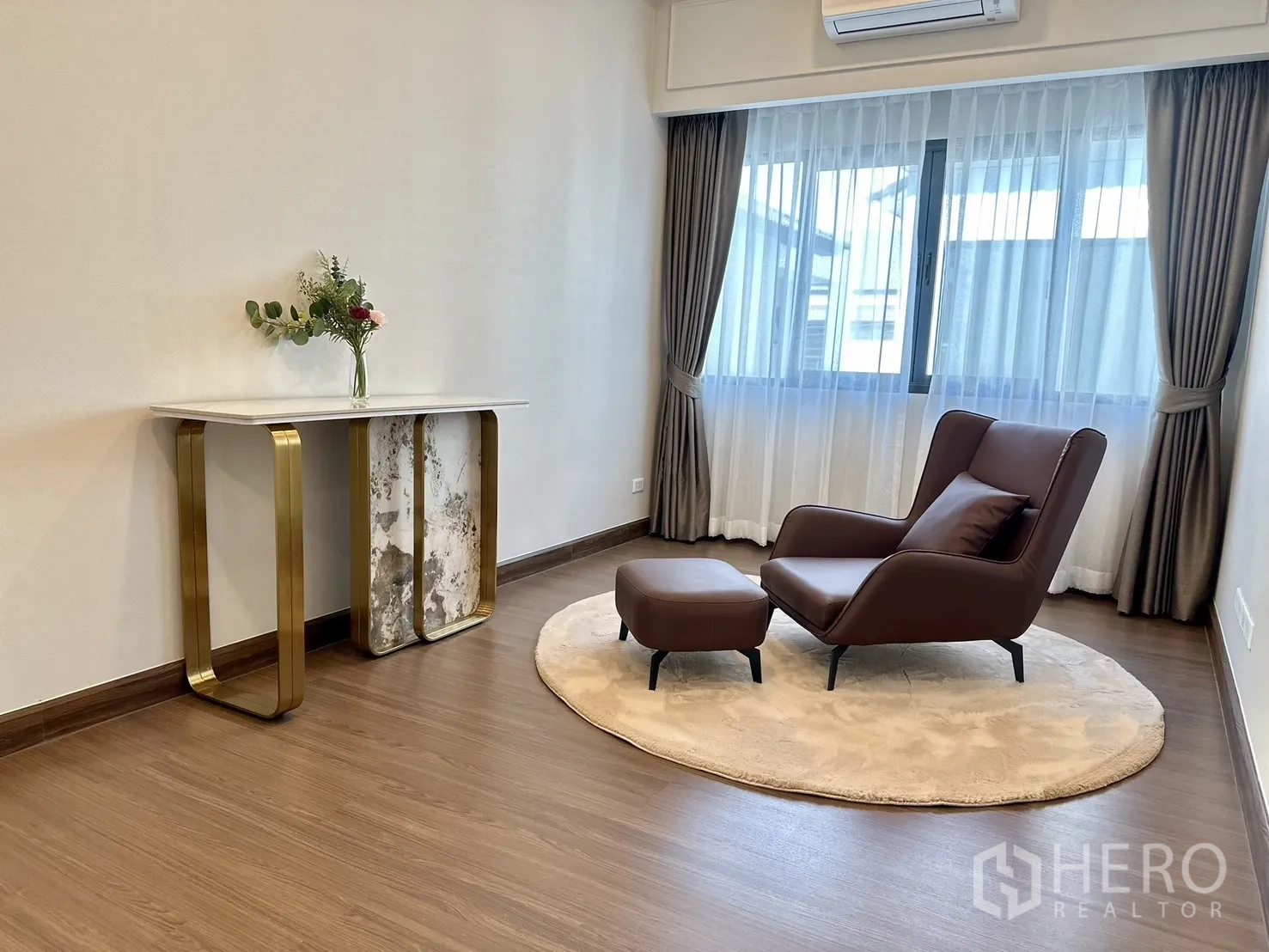Detached House for rent or sale - Upper-floor lounge or reading corner with leather chair and ottoman on round rug by wide window.