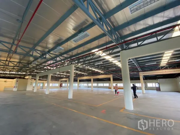 Factory for rent in Khlong Toei, Bangkok - Expansive open-plan factory floor with steel truss ceiling and fire piping.