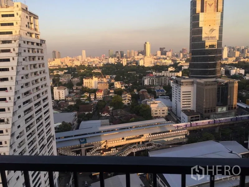 公寓 出租在Phaya Thai, Bangkok - 高楼阳台视野，俯瞰Ari轻轨与曼谷天际线的黄昏景色。