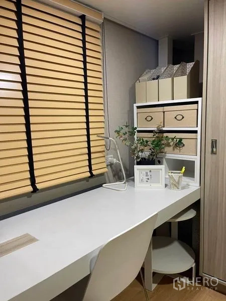 Condominium for rent in Ratchathewi, Bangkok - Compact home office corner with white desk, storage drawers and wood blinds in Ratchathewi condo.