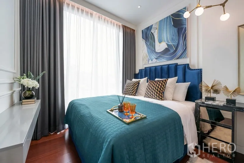 公寓 出租在Watthana, Bangkok - 卧室采光佳，蓝色软包床头与青绿色床品。