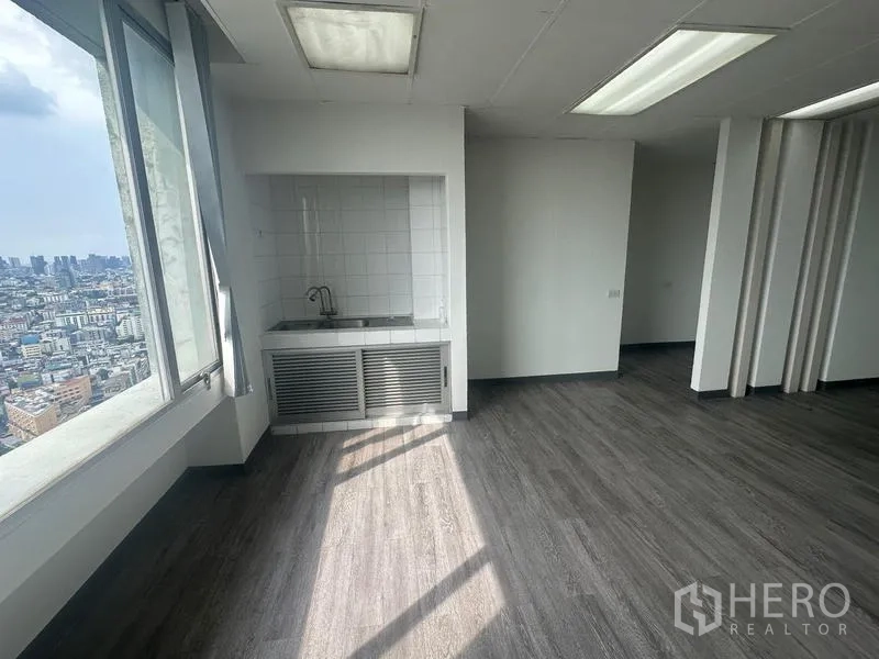 Office Space for rent - In‑unit pantry with sink and tiled backsplash beside a large window facing the city.