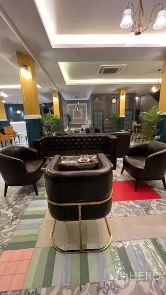 Retail Space for rent in Khlong Toei, Bangkok - Cozy seating corner with black leather armchairs, brass details, and colorful patterned flooring.