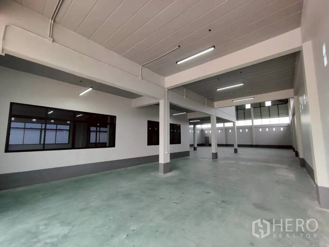 โรงงาน for rent in Krathum Baen, Samut Sakhon - โซนผลิตชั้นล่าง พื้นคอนกรีต เสาโครงสร้าง และหน้าต่างภายในบานยาว