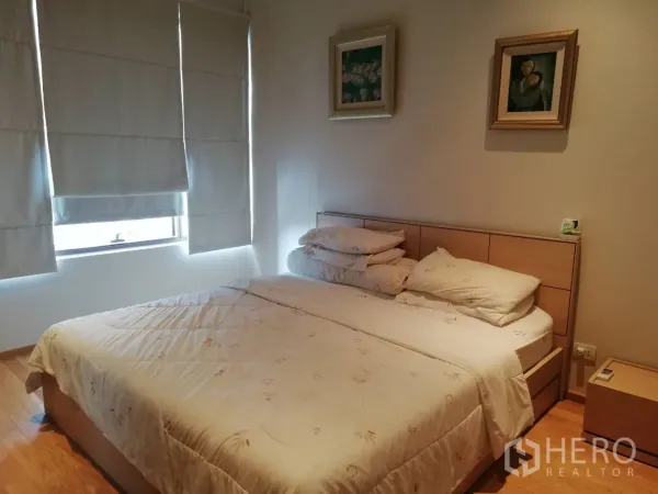 Condominium for sale in Khlong Toei, Bangkok - Second bedroom with double bed, bedside table and wall art.