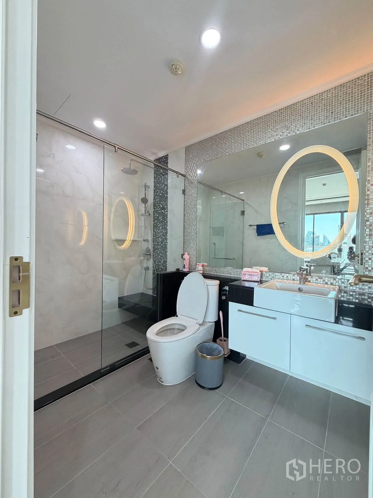Condominium for sale in Watthana, Bangkok - Bathroom with illuminated mirror, vanity storage, and walk-in shower.