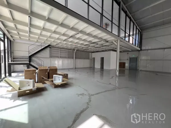 Warehouse for rent in Bang Na, Bangkok - Ground-floor area beneath mezzanine with staircase and boxes, ready for office fit-out.