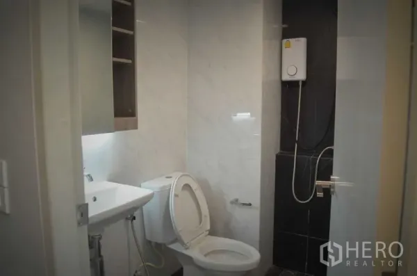 店屋 出租或出售在Khlong Toei, Bangkok - 整洁的瓷砖浴室，配坐便器、洗手盆和电热淋浴器。