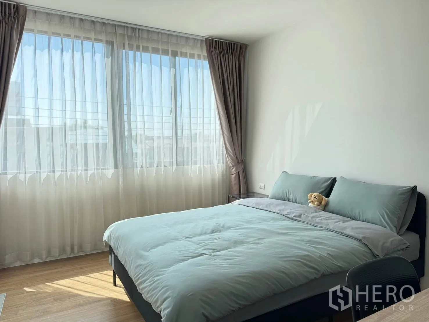 Townhouse for rent in Saphan Sung, Bangkok - Sunlit guest bedroom with large windows, sheer drapes and soft natural light.