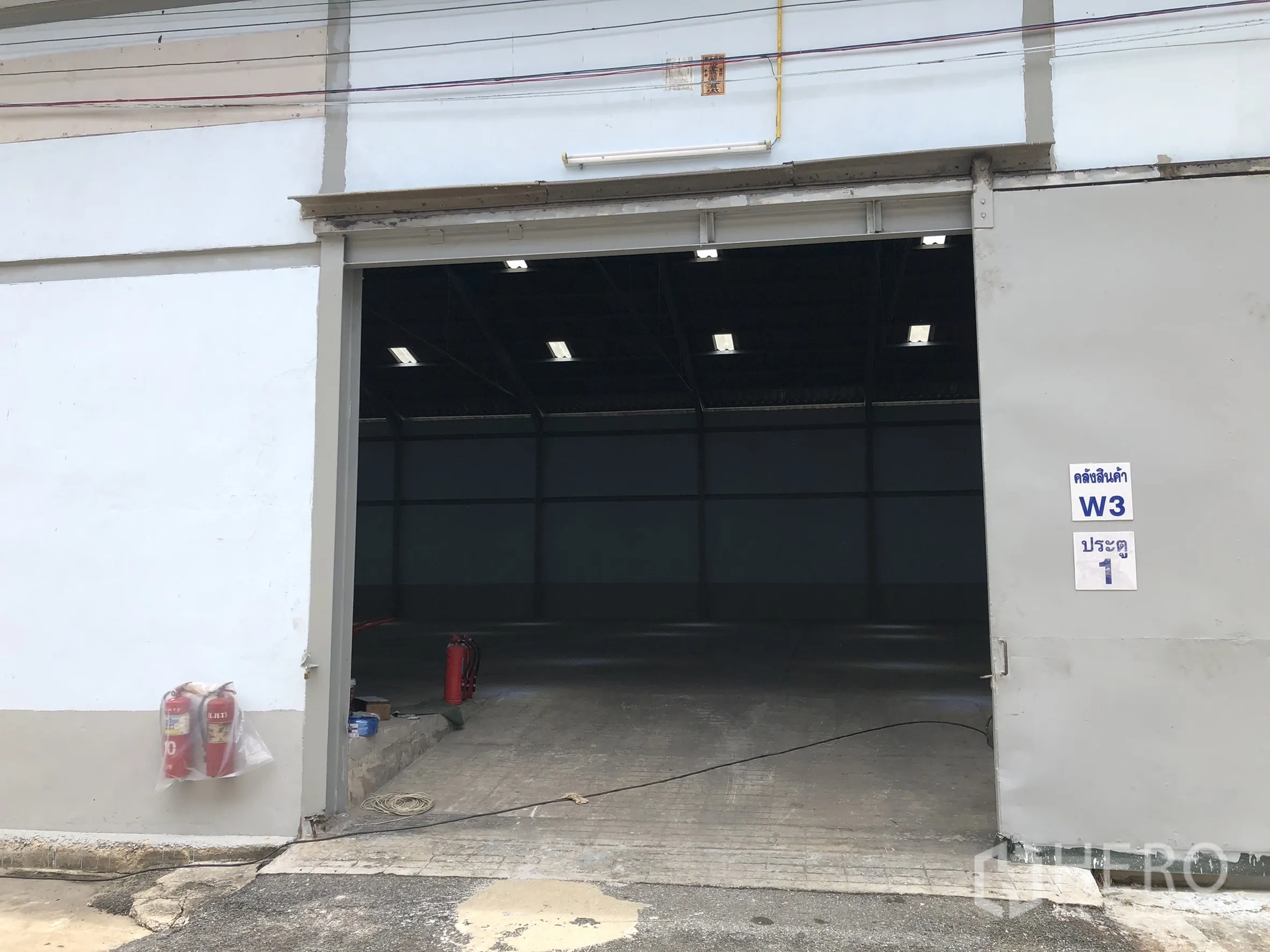 Factory for rent in Mueang Samut Prakan, Samut Prakan - Exterior sliding shutter entrance to the factory with ramp access.