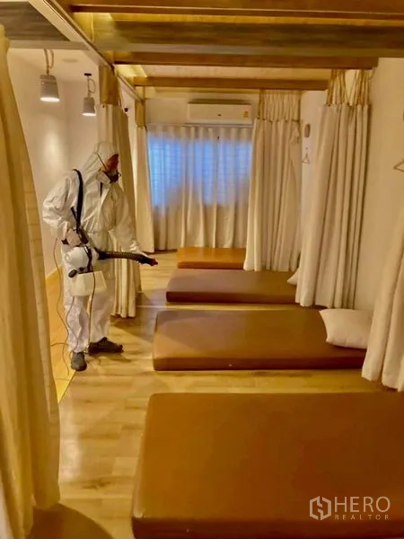 Shophouse for rent in Khlong Toei, Bangkok - Thai massage room with multiple floor mattresses, curtain dividers and warm lighting.
