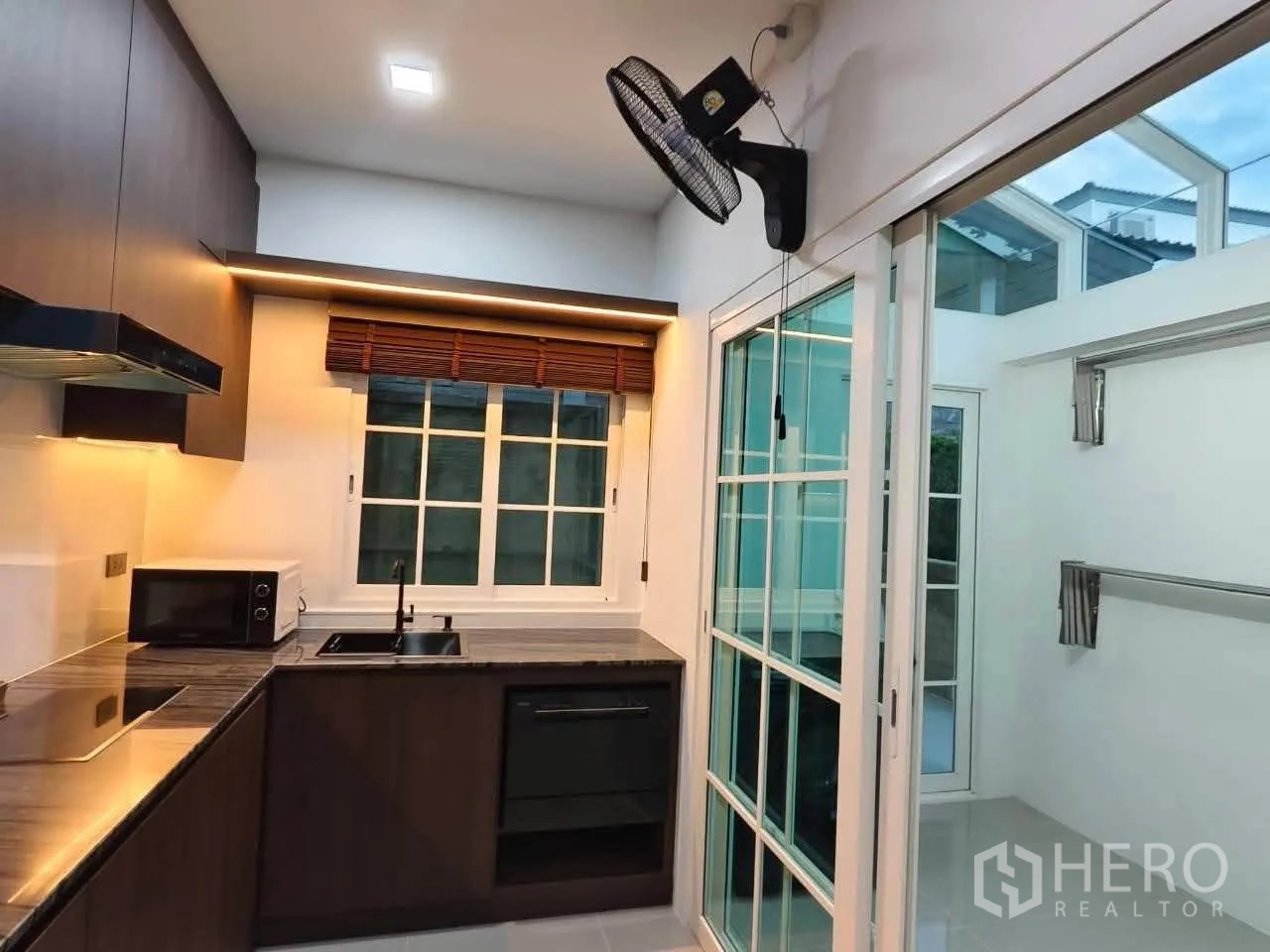บ้านเดี่ยว for rent in Bang Phli, Samut Prakan - ห้องครัวบิวท์อินพร้อมเตา เตาอบ และประตูบานเลื่อนไปยังโซนซักล้าง.