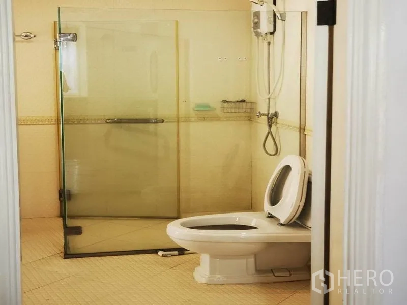Detached House for rent in Mueang Samut Prakan, Samut Prakan - Bathroom with glass-enclosed shower, handheld showerhead and toilet.