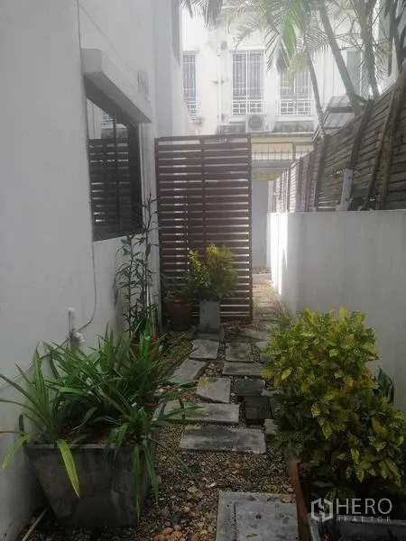 联排别墅 出租在Wang Thonglang, Bangkok - 侧院小花园，踏步石与隐私屏风、盆栽。