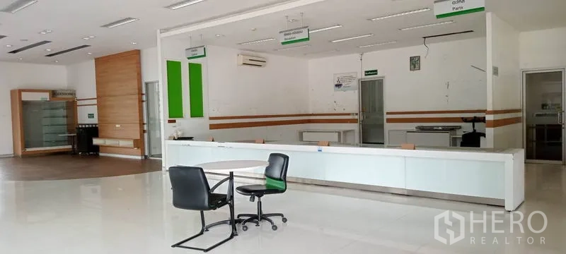 Warehouse for rent or sale in Lam Luk Ka, Pathum Thani - Bright reception and parts counter area with built-in desks and signage.