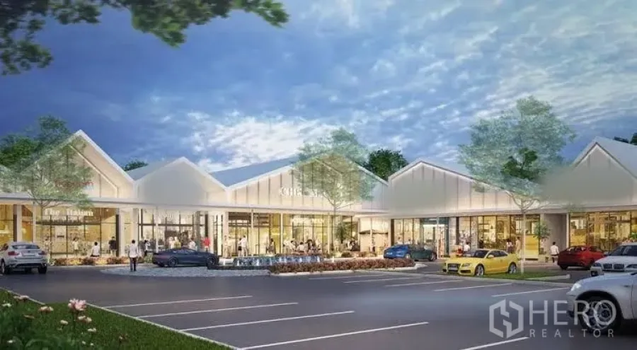 Retail Space for rent in Khlong Toei, Bangkok - Contemporary low-rise retail plaza with glass-fronted shops, trees, and customer parking at dusk in Khlong Toei, Bangkok.